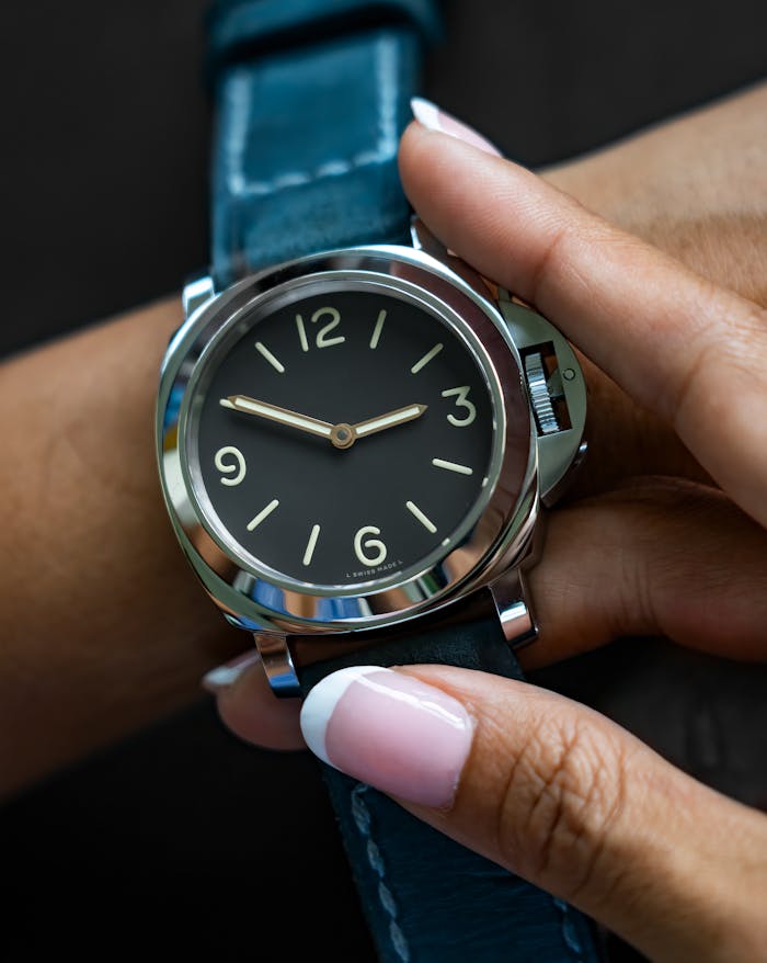 Close-up of an elegant wristwatch with a blue leather strap on an adult